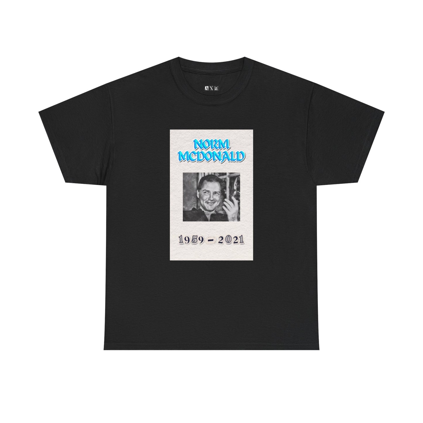 Norm McDonald black unisex heavyweight tee shirt honoring the comedy legend. It features a smiling portrait with electric blue lettering and the years 1959–2021. A timeless tribute to be enjoyed by any Norm McDonald fan.