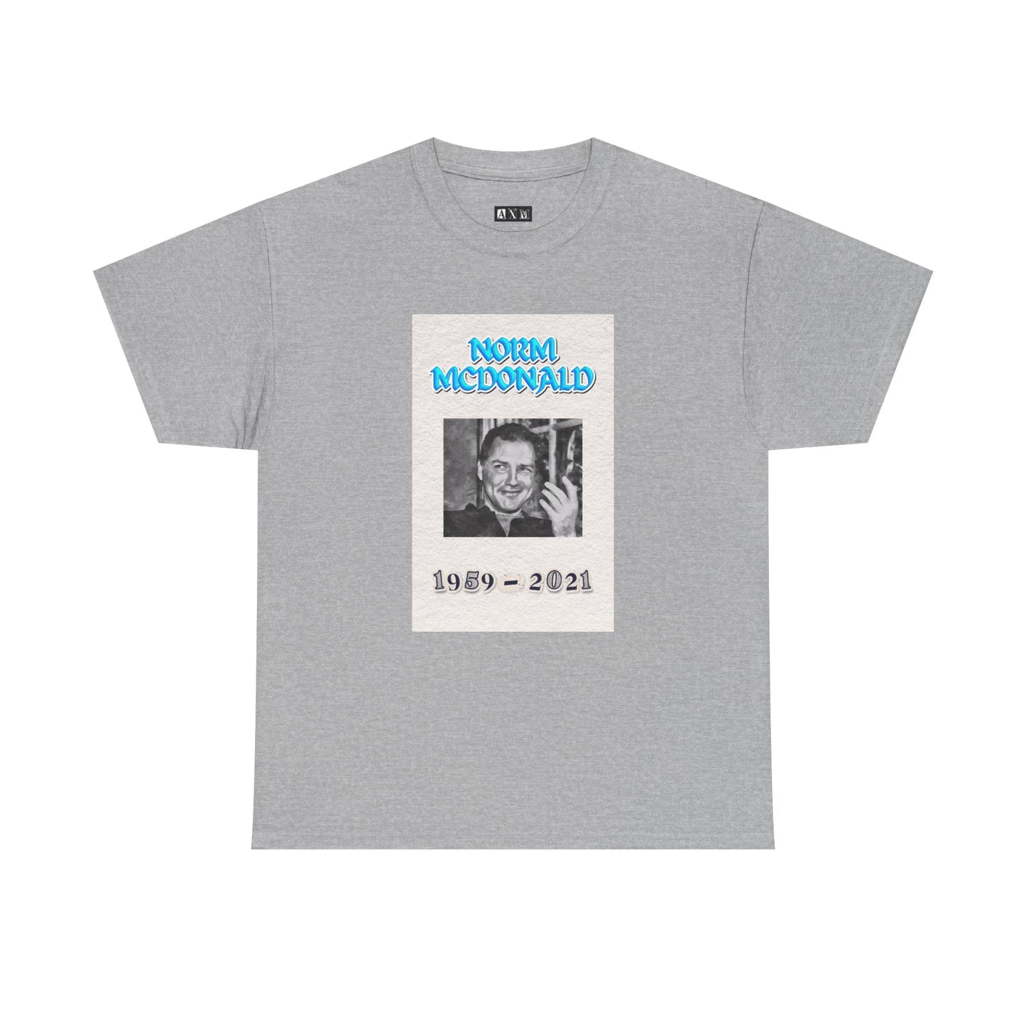 Norm McDonald black unisex heavyweight tee shirt honoring the comedy legend. It features a smiling portrait with electric blue lettering and the years 1959–2021. A timeless tribute to be enjoyed by any Norm McDonald fan.